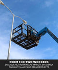 Rock Solid Four By Six Foot Mesh Telehandler Work Platform With Heavy Duty Safety Cage For Forklift Aerial Access And No Sweat Roof Tree Painting Jobsite Repairs, shown in use with two workers.