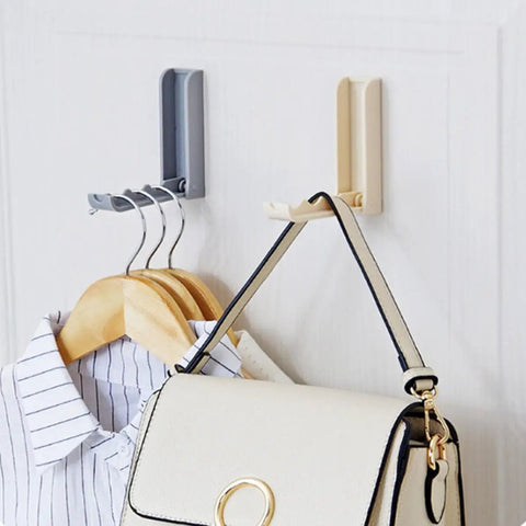 Slick Foldable Wall Hooks With Adhesive Backing For Space Saving No Drill Setup To Hang Jackets Purses Hats Or Dog Leashes In Foyer Closet Easy Install Design Works As A Lifesaver To Keep Home Clutter Free Always Two Pack. Image shows gray and beige foldable hooks holding a purse and shirt.
