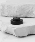 Upper Jet Nozzle S129 Replacement 1.0mm Plastic Nozzle for Sodick EDM Wire Cut Machines, black, shown on stone surface.