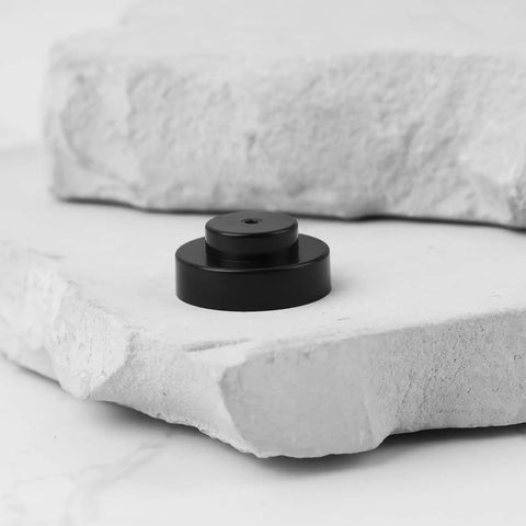 Upper Jet Nozzle S129 Replacement 1.0mm Plastic Nozzle for Sodick EDM Wire Cut Machines, black, shown on stone surface.