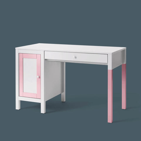 White and pink children's desk with drawer and cabinet on dark background.