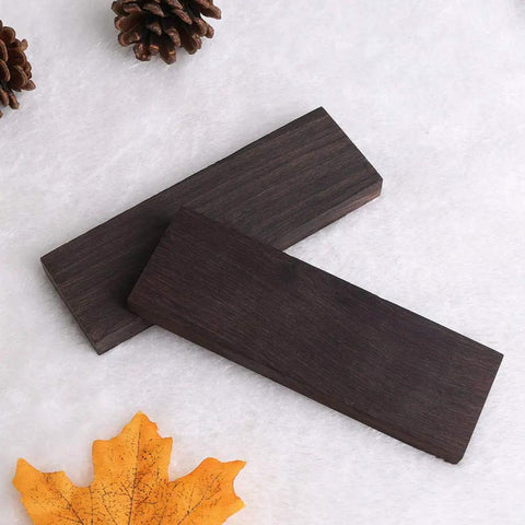 Two Piece Black Ebony Lumber Wood Handle Plate For DIY Tools And Musical Instrument Projects, Three Eighths Inch By One And A Half Inch By Five Inch, Dark Premium Wood With Rich Open Grain, Ideal For Knife Handles And Grips on white background with pinecones and leaf