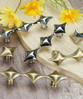 Spruce Up Your Day To Day Kitchen Cabinets Or Lazy Sunday Bathroom Vanities With These Clean Star Design Drawer Pulls In Crisp Silver Finishing. Modern star pattern silver and gold drawer handles displayed on wood.