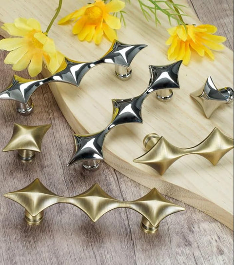 Spruce Up Your Day To Day Kitchen Cabinets Or Lazy Sunday Bathroom Vanities With These Clean Star Design Drawer Pulls In Crisp Silver Finishing. Modern star pattern silver and gold drawer handles displayed on wood.