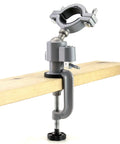 Sturdy Aluminum Alloy Bench Vise Clamp With Breezy 360 Spin And Quick 45 Degree Tilt securely clamped on a wooden plank.