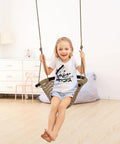 Child on hand knitted toddler swing seat with adjustable ropes, indoor setting, light brown, ergonomic and safe design.