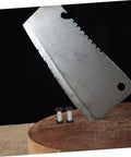 Heavy Duty Stainless Steel Bindery Rivets And Self Tapping Metal Handle Screws For Knockout DIY Crafts And Leather Work Built Like A Tank With Badass Grip Corrosion Resistant hardware next to a cleaver on a wooden surface.