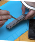 Repairing a cracked smartphone screen on a Heavy Duty Silicone Soldering Mat Heat Resistant Workbench Repair Pad for Phones Tablets PC And Watches.