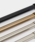 Various finishes of drapery curtain rod with end cap style design, 1 inch telescoping pole, adjustable 48 to 86 inches, shown in black, warm gold, brushed nickel, and satin nickel.