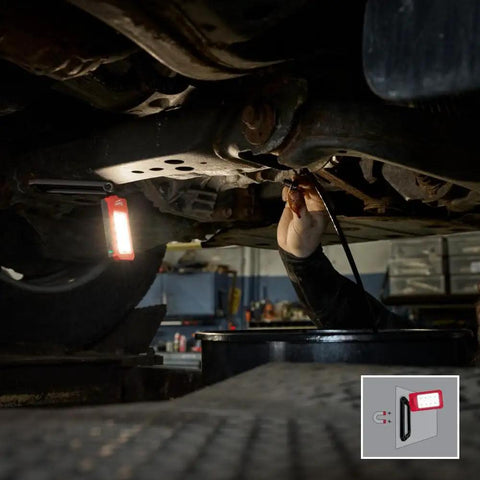 Low Profile Magnetic Task Light With Three Modes illuminating car undercarriage during repair, attached to metal surface for easy inspection.