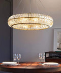 Sleek Modern Crystal Chandelier Ceiling Light With Adjustable Gold Pendant Ring Featuring Quick Setup Eight Bulb Glass Halo Fixture To Level Up Kitchen Dining Decor hanging above a wooden dining table.