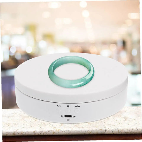 White Electric Rotating Display Stand For Jewelry Watches And Cosmetics Automatic Turntable Showcase With Stable Structure Energy Saving Design Perfect Gift Idea featuring a green ring on top.