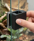 Rock Solid Sliding Door Lock For Reptile Enclosures with secure latch attached to glass tank, showing hand installation.