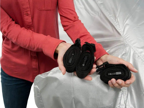 Heavy Duty All Weather Car Cover Gonna Shield Your Tesla Model S Like Armor while showcasing securing straps in a person's hands.