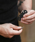 Close-up of a person holding 8 Piece Black Zinc Alloy Folding Table Flip Top Hinges With 180 Degree Round Edge Design.