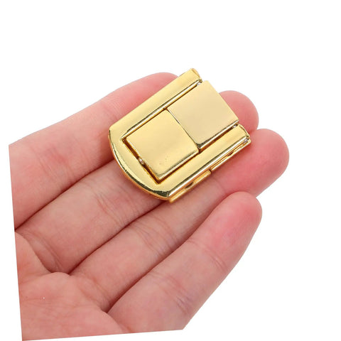 Hand holding golden zinc part of Retro Iron Toggle Latch Kit For Wooden Chests Jewelry Boxes And Cabinets 5 Piece Secure Clasp Easy Install