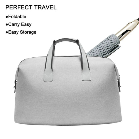 Travel duffel bag next to a curling iron wrapped in silicone cover for easy packing