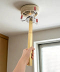 Professional Smoke Transducer Removal Tool With Extended Steel Rod And Secure Jaw Grip being used to replace ceiling smoke sensor.