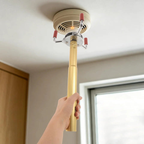 Skip The Ladder Drama With This Sturdy Aluminum Alloy Smoke Detector Remover Tool reaching for a ceiling fire sensor.