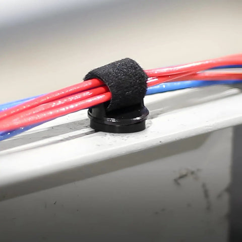 Magnetic Hook and Loop Cable Holder fits straps up to three quarters inch wide, securing red and blue cables on metal surface