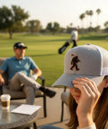 Bigfoot Patch Golf Hat With Sasquatch Holding A Golf Club Heather White Trucker Snapback worn by a woman on golf course