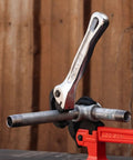 Top Shelf Nine Inch Compact Pipe Wrench Built Like A Tank For Killer Grip On Half To One Inch Fittings, chrome plated, gripping metal pipes in a vise.