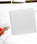 Square white DIY Concrete Stepping Stone Mold for patio and garden paving, featuring a decorative spiral pattern.