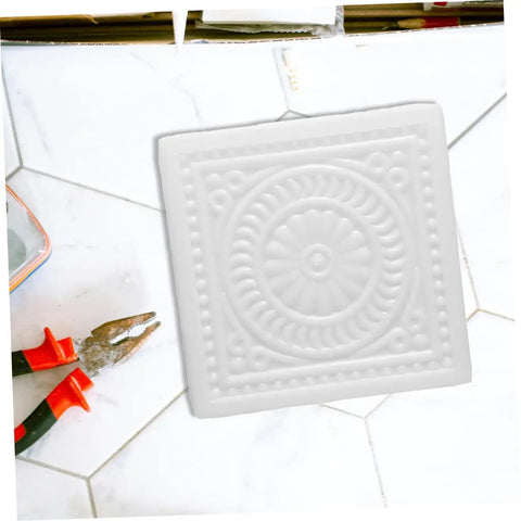 Square white DIY Concrete Stepping Stone Mold for patio and garden paving, featuring a decorative spiral pattern.