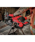 Worker using Ultra Light 18V Cordless Band Saw With Brushless Motor And Constant Power Tech Delivers The Fastest Cuts In Its Class For Portable Tough Jobs On The Jobsite, No Hype for cutting pipe