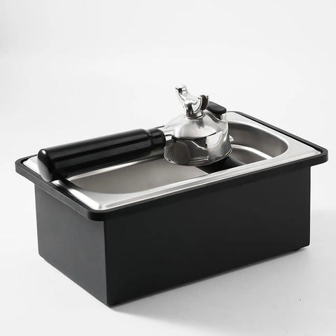 Built Like A Tank Stainless Steel Knock Box With Removable Interior Grounds Bin For Espresso Setups and Home Baristas Made For Busy Coffee Shops Without The Headache Featuring Durable Metal Construction, angled view with handle.