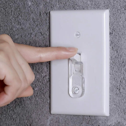 Person using Clear Toggle Switch Plate Guard from 10 Pack for Indoor and Outdoor Wall Plates on a standard wall switch.