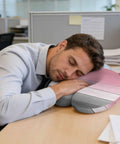 Man napping at desk using U Shaped Memory Foam Travel Neck Pillow With Pink Wood Grain Finish for head support in office