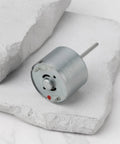 5.9V RF-310T-11400 Mini DC Motor Shaft Length 22mm and Diameter 24mm on a white stone background