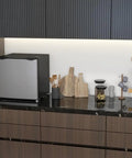 Real Deal 1.1 Cubic Foot Upright Mini Freezer With Quick Dial Thermostat on a kitchen counter with utensils.