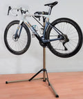 Adjustable Height Bike Repair Stand With Foldable Design For Home And Shop, 360 Degree Rotating Clamp, Anti Slip Feet On Triangular Base, 65 Lbs Load Capacity holding a road bike