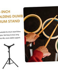 Hella Sturdy 12 Fold Snare Drum Stand Rack With Heavy Duty Accessory Holder For Practice Pads And Gear Compact Road Ready Top Shelf Black Finish, viewed from above with drumsticks on pads.