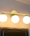 Rock A Stylish Mid Century Modern Vibe In Your Bathroom With These Three Light Gold Vanity Fixtures Complete With Frosted Milk Glass Globes