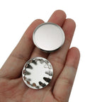 12 Pack Stainless Steel Knockout Plugs For Electrical Boxes Featuring Knurled Grip And No Sweat Tap In Install Rock Solid Seal Keeps Your Panel Jobs Hella Slick in hand showing top view and interior detail.