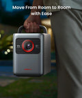 Person carrying Cosmos 4K SE Smart Projector With Dolby Vision And 200 Inch Screen 1800 ANSI Lumens HybridBeam at night