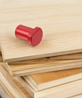 Red aluminum clamp on wood, part of Six Piece Aluminum Workbench Dog Clamp Set With Low Profile Table Stops And Scratch Resistant Design