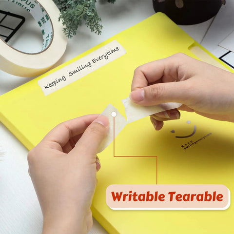 Hands tearing a piece of beige tape over a yellow notebook, showcasing the easy tear feature of the 30 rolls masking tape bulk 55 yards each for classroom labeling crafts office school projects super handy easy tear and clean removal beige white 1 inch general purpose tape.