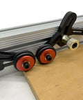 Close-up of Upgraded Router Table Saw Roller Feeder With One Way Bearings And Anodized Aluminum Body, showcasing smooth rollers and clamp.