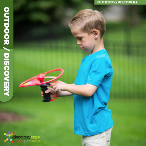 Child playing with Sky Spin Flying Aerial Disc Launcher With Two Large Wings Kid Powered STEM Toy in a backyard setting