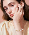 Woman wearing a bracelet with Eight Pieces Real 18K Gold Plated Brass Spring Gate Rings With Oval Clasps Carabiner Snap Hooks Keyring Buckles For Jewelry Making Findings Supplies Necklace Bracelet DIY Crafts Easy Clip.