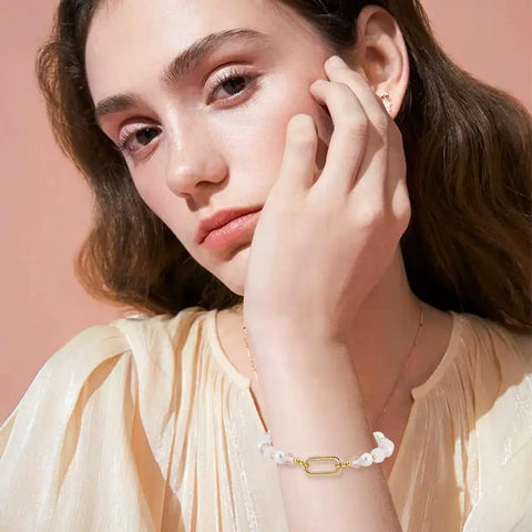 Woman wearing a bracelet with Eight Pieces Real 18K Gold Plated Brass Spring Gate Rings With Oval Clasps Carabiner Snap Hooks Keyring Buckles For Jewelry Making Findings Supplies Necklace Bracelet DIY Crafts Easy Clip.