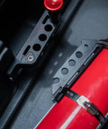 Close-up of Slick Under Seat Fire Extinguisher Bracket For Ineos Grenadier Truck with red extinguisher and aluminum mount.