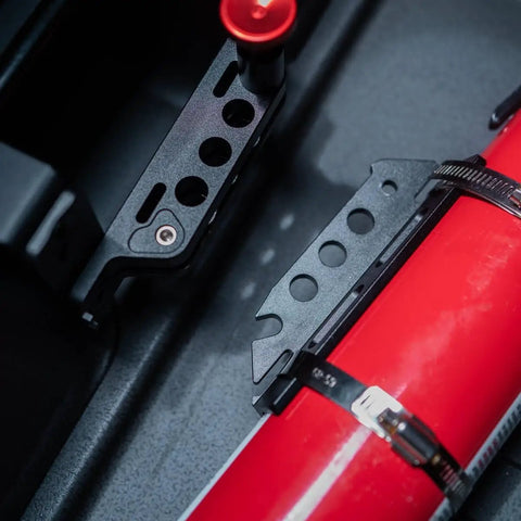 Close-up of Slick Under Seat Fire Extinguisher Bracket For Ineos Grenadier Truck with red extinguisher and aluminum mount.