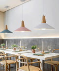 KCEYANB Adjustable Height Pendant Light Modern Simplicity Metal Hanging Lamp in blue, pink, and white shades over a dining table.