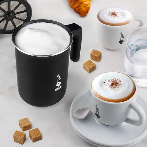 Tutto Crema Milk Frother Black Barista Grade, 1L Capacity with double fine mesh insert shown next to cappuccino cups on a table.