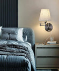Bedroom with Bedside Wall Mount Light With Dimmable Switch And USB Port Swing Arm Fabric Shade Wall Sconce with plug-in cord on wall.